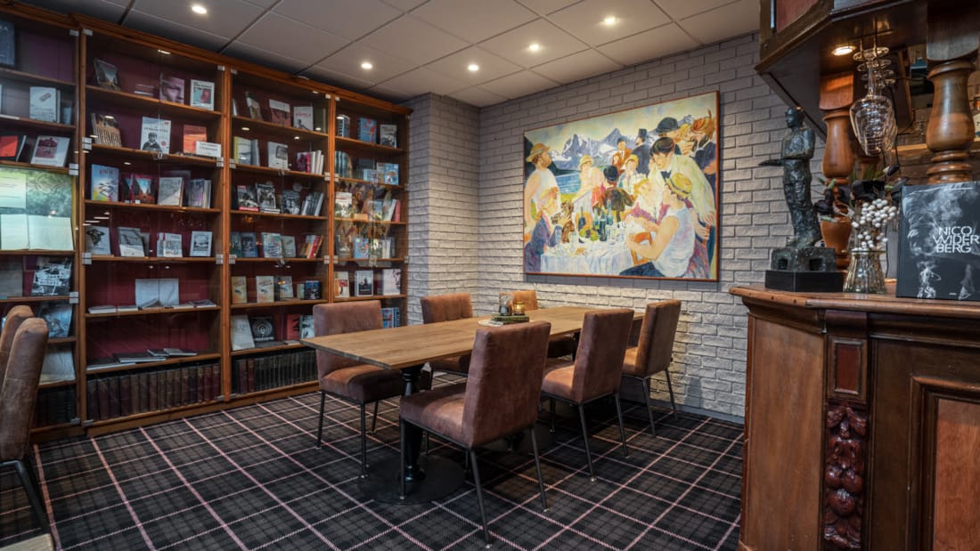 Le bar-bibliothèque de Saabye avec des étagères le long des murs, des tables et des sièges.