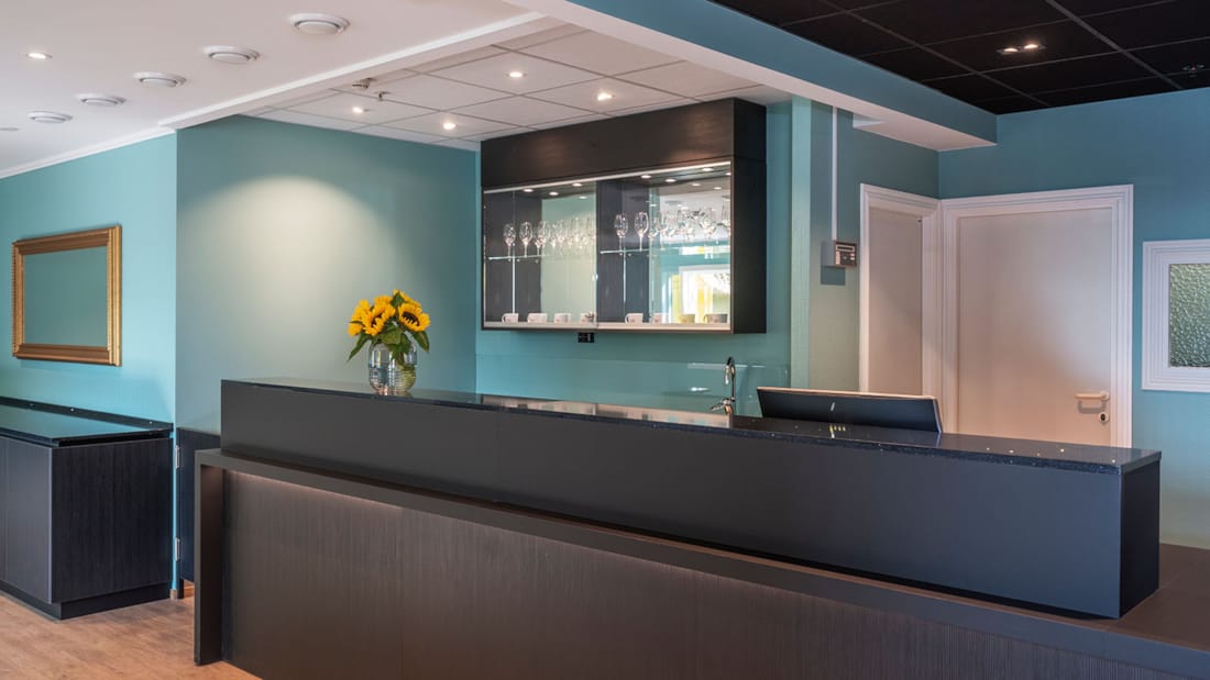 Bureau de réception noir, murs turquoise, parquet, plafond blanc