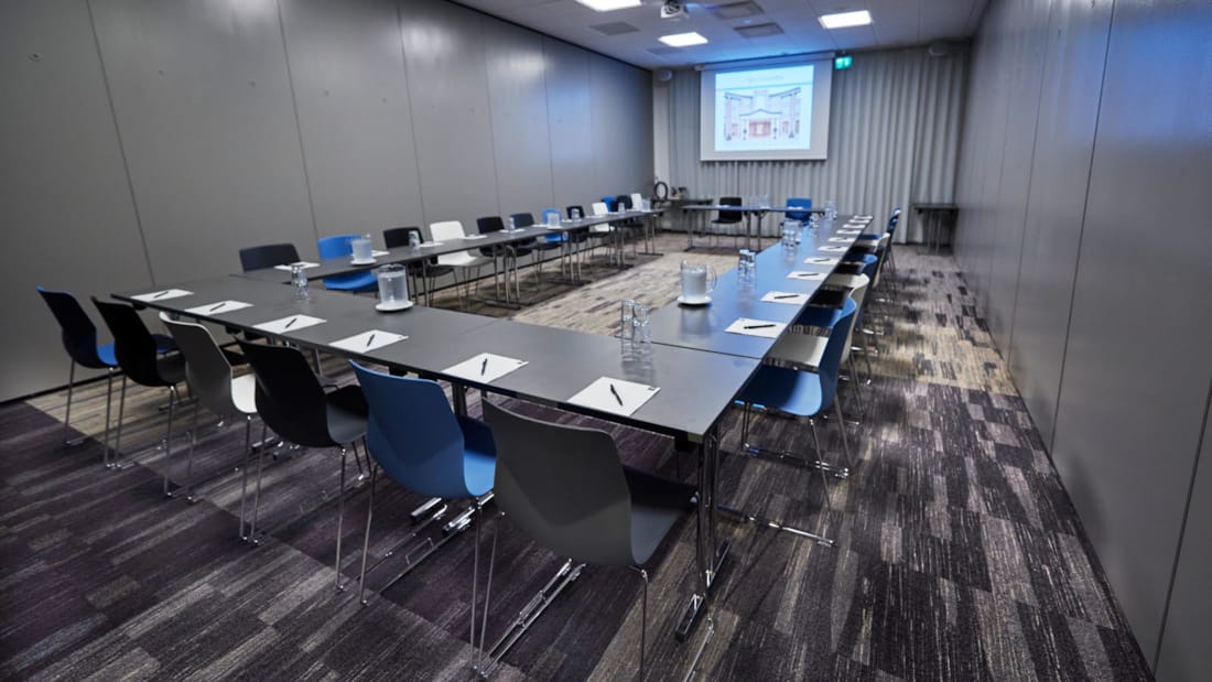Modern conference room in dark colours with projector and lots of light