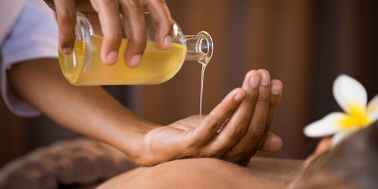 Massage oil is poured into hand in an relaxing environment