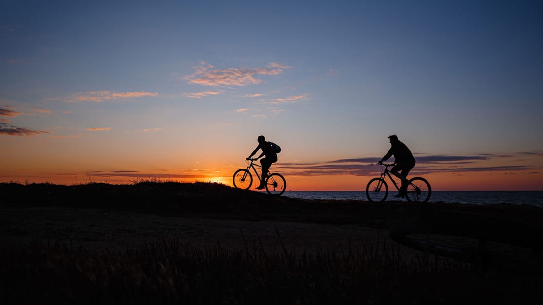 Syklister i solnedgang.