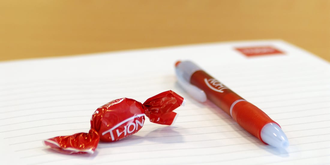 Pen, paper and wrapped sweet on desk in meeting space