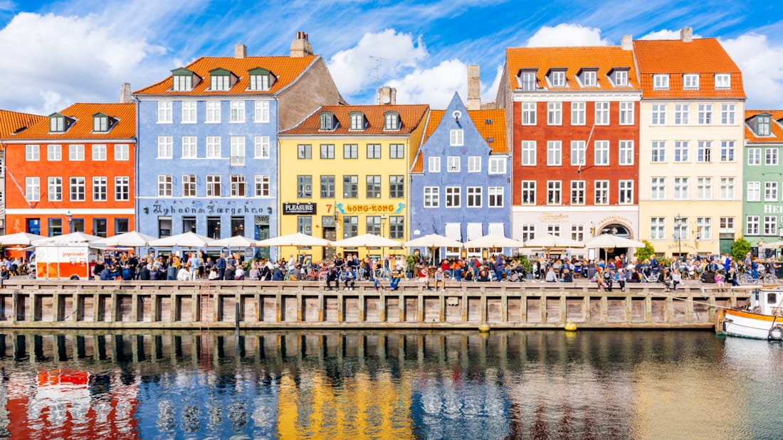 Farverige huse på Christianshavn, der spejler sig i vandet