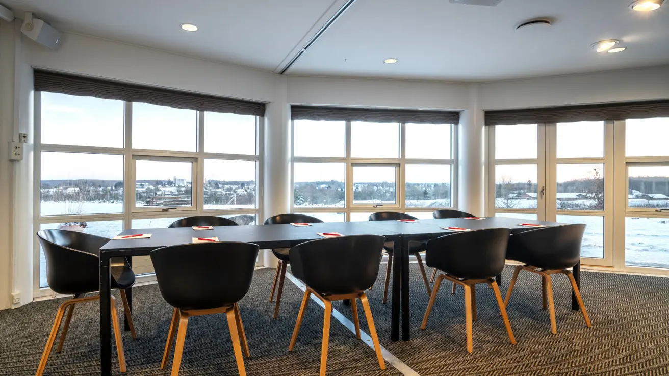 Gros plan des tables et des chaises dans la configuration de salle de classe. Il y a des stylos et du papier sur les tables