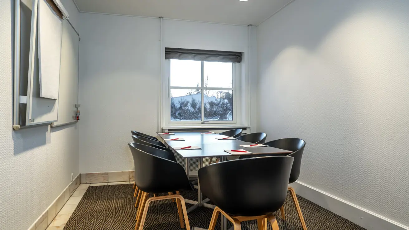 Gros plan des tables et des chaises dans la configuration de salle de classe. Il y a des stylos et du papier sur les tables