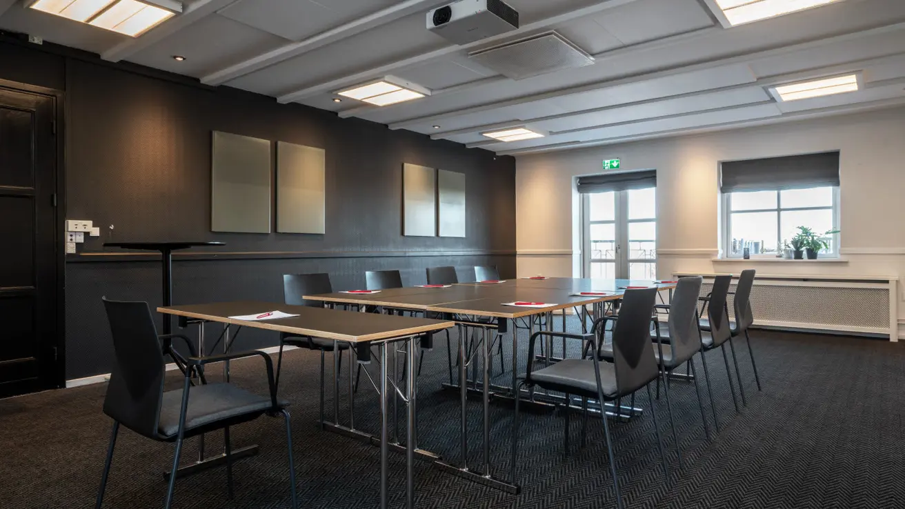 Gros plan des tables et des chaises dans la configuration de salle de classe. Il y a des stylos et du papier sur les tables