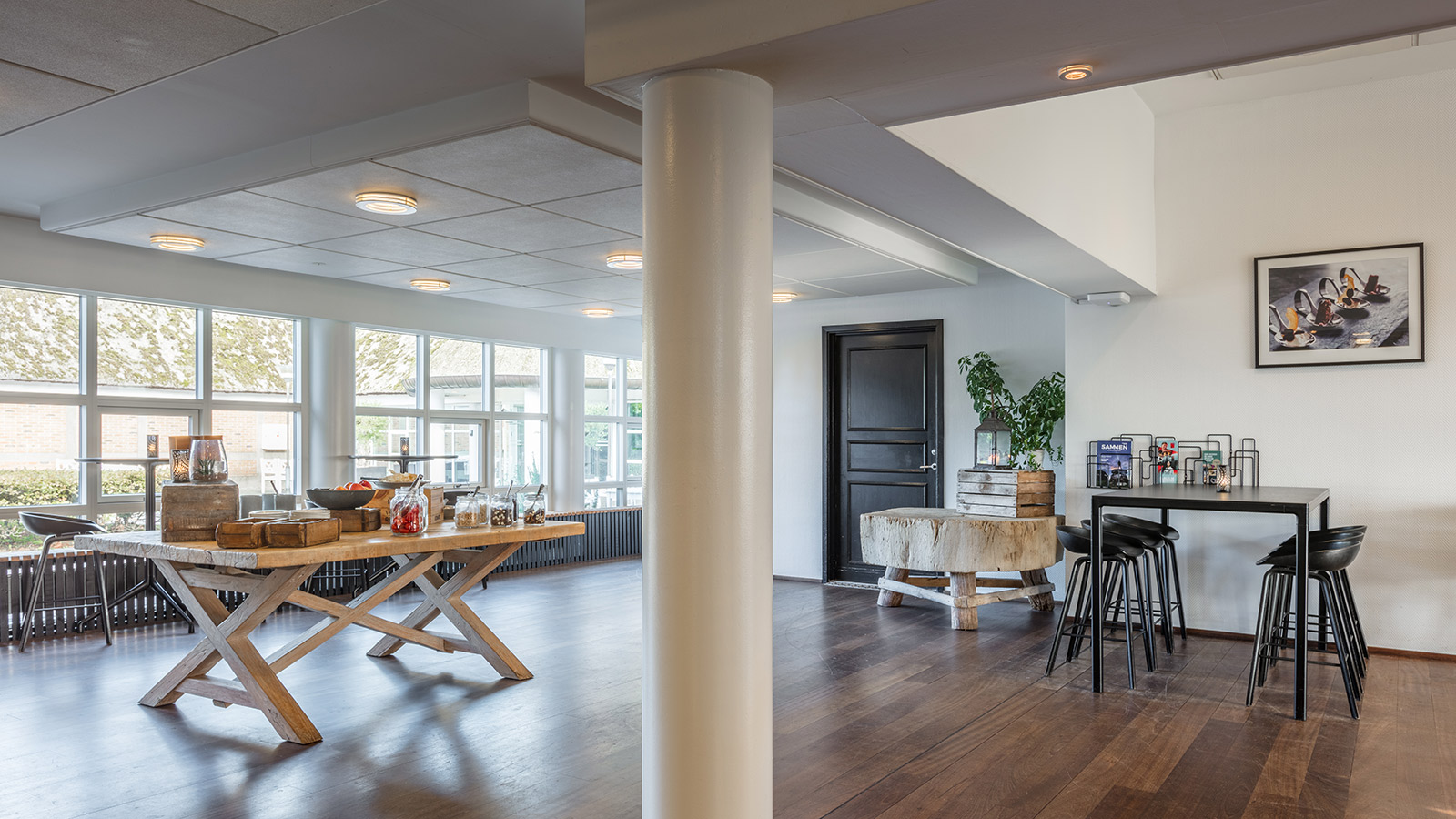 Pauseområde med bord med mat til venstre og barstoler og bord til høyre