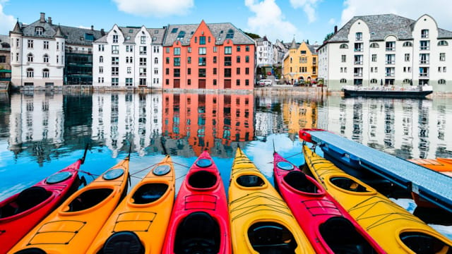 Many kayaks in a row in the water in the centre of Ålesund