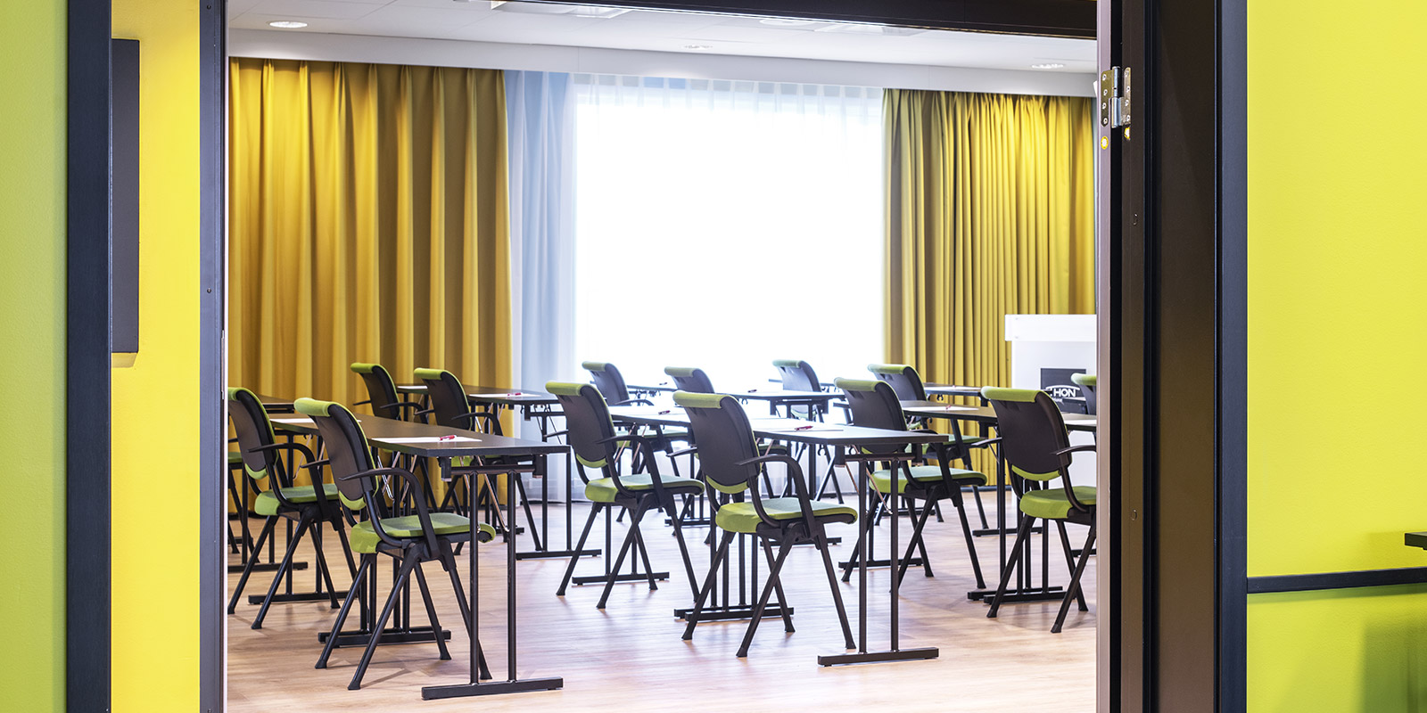 Mötesrum Gapahuken med klassrumsmöblering sett från korridoren utanför