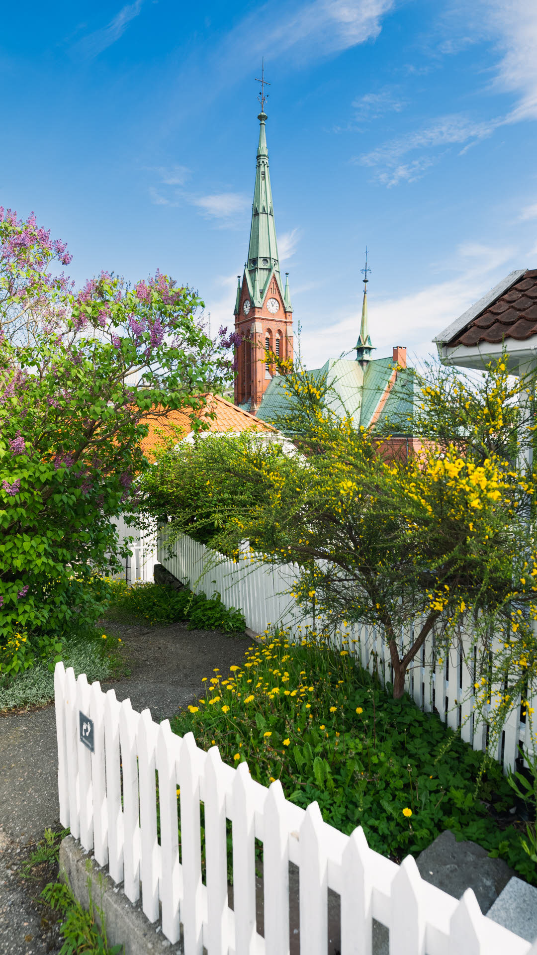 Arendal-kerk op de achtergrond, met gebouwen, tuinen en sites op de voorgrond.