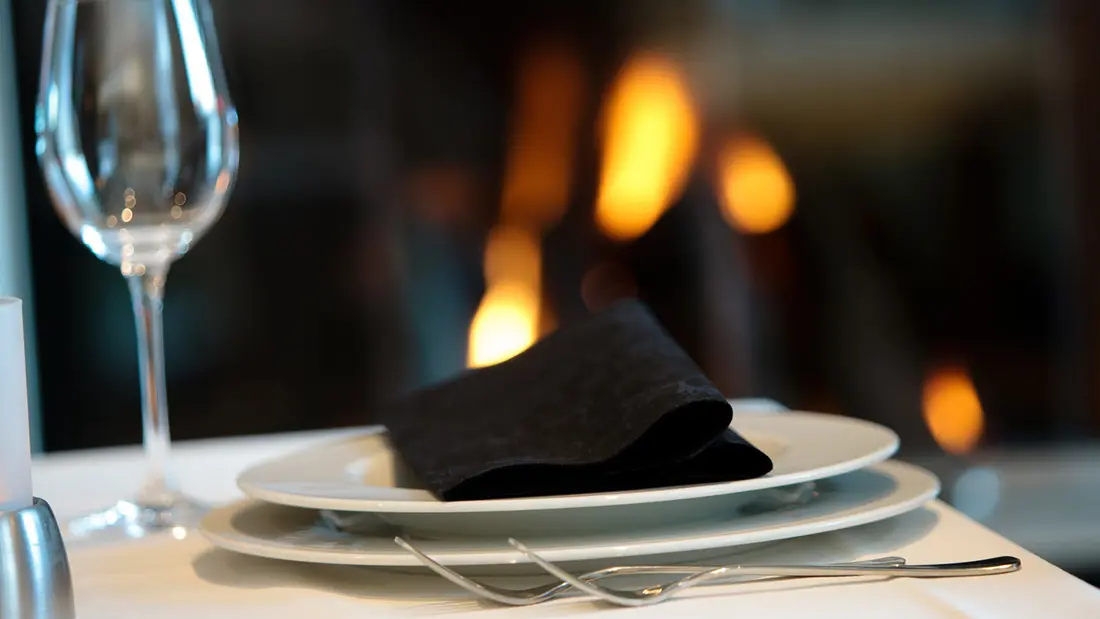 Gedeckter Tisch vor brennendem Kamin