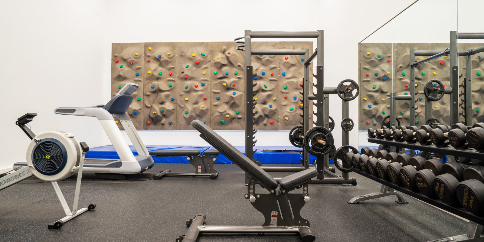 Hotell ved Flesland med treningsrom med rikelig av treningsmanualer, apparater, klatrevegg, tredemølle og romaskin.