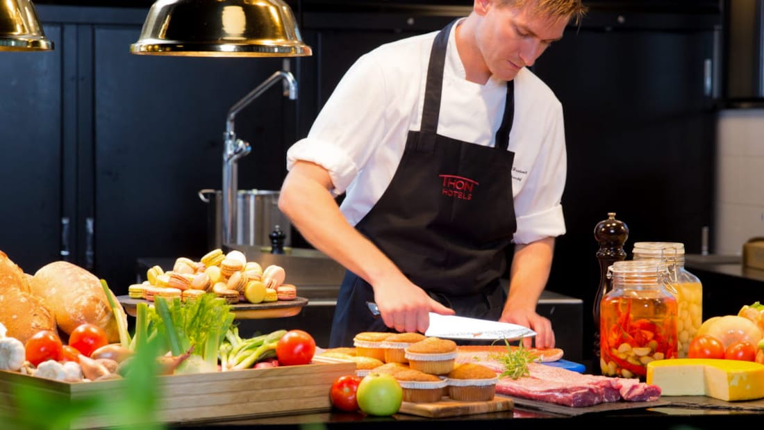 Kok skærer grøntsager i hotellets køkken