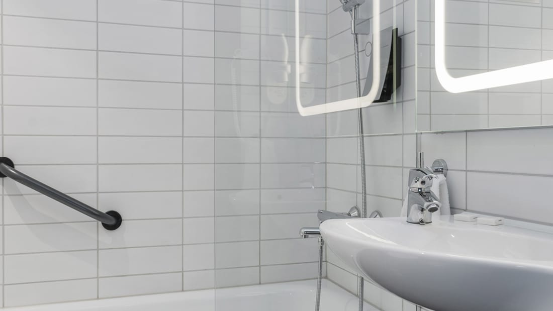 Håndvask og bruser med badekar i superior room på Thon Hotel Orion i Bergen
