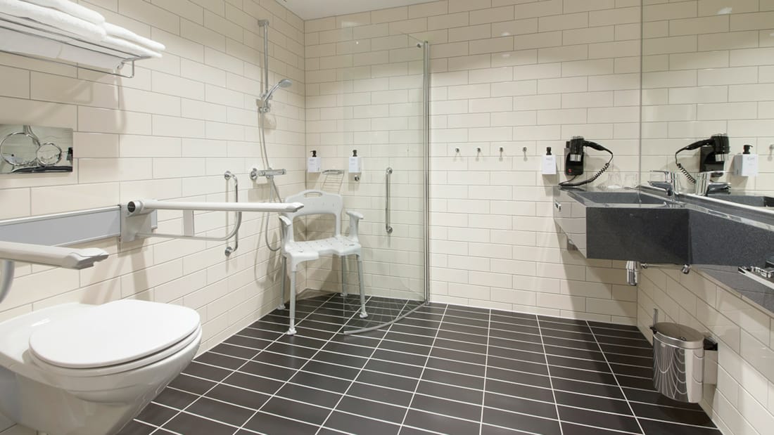 Bathroom in a disability-friendly room at Elgstua Hotel in Elverum