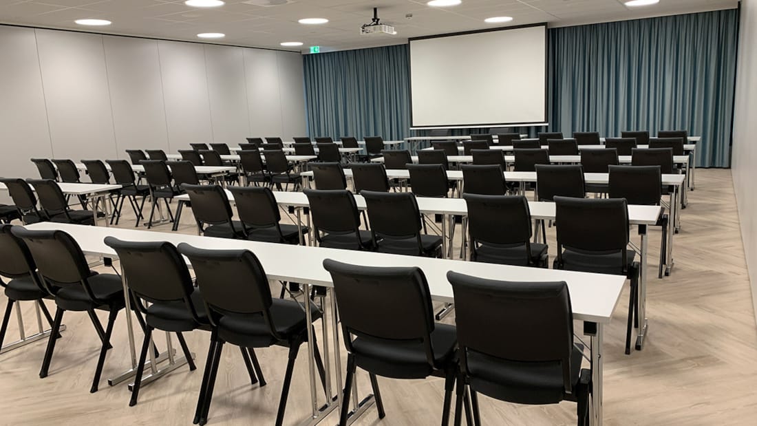 Elvelyst konferencelokale med klasseværelsesopsætning på Hotel Central i Elverum