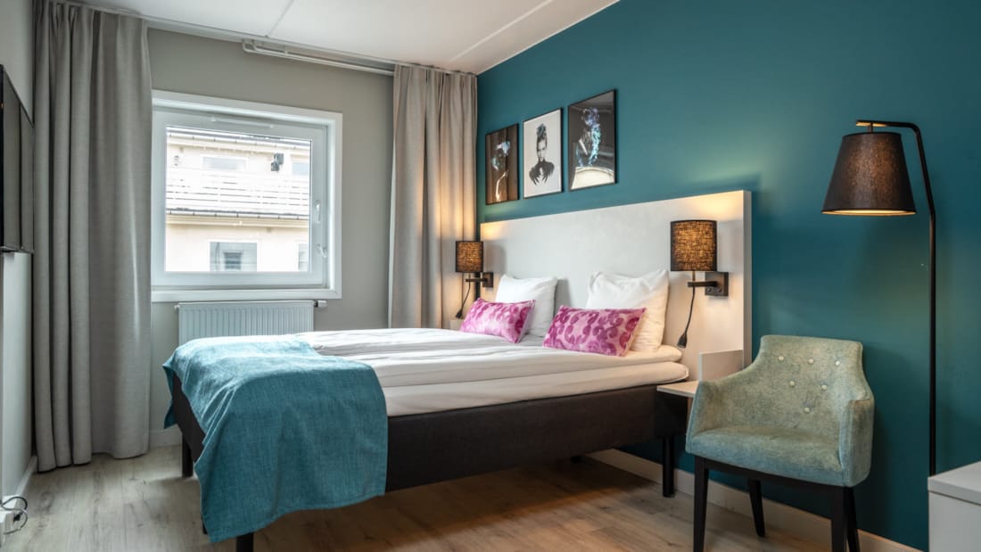 Doppelbett und zwei Stühle eines Standard-Zweibettzimmers im Hotel Central in Elverum