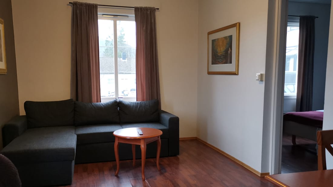 God plass med skrivebord og sofa i budget room på Hotel Førde