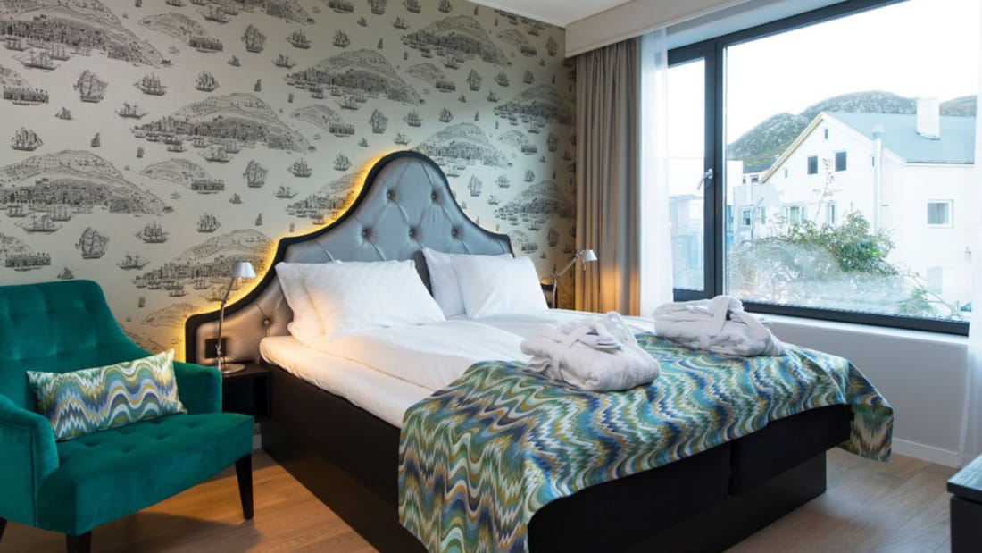 Dubbelsäng och fåtölj på avskilt sovrum i Junior Suite på Thon Hotel Fosnavåg