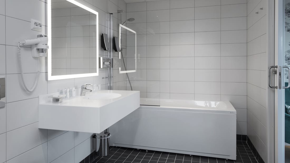 Håndvask og badekar med bruser i juniorsuite på Thon Hotel Fosnavåg