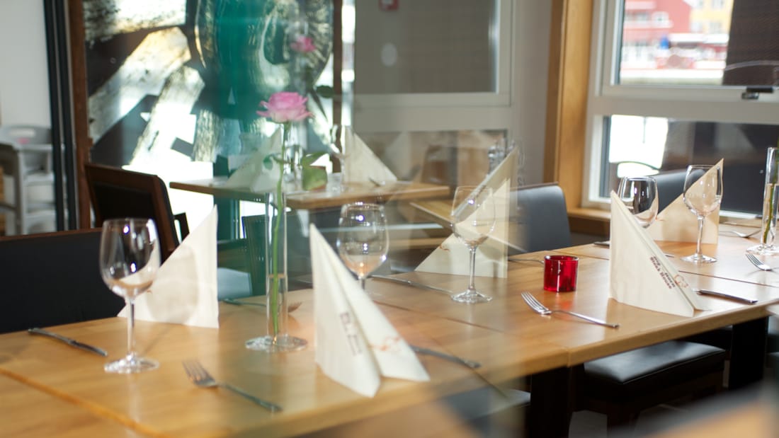 Delvist dækket spisebord i restaurantlokalet Brygga Mat og Vinhus