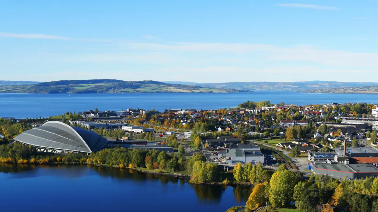 Aerial view of Hamar. Vikingskipet on the left. Mjøsa and mountains in the background.