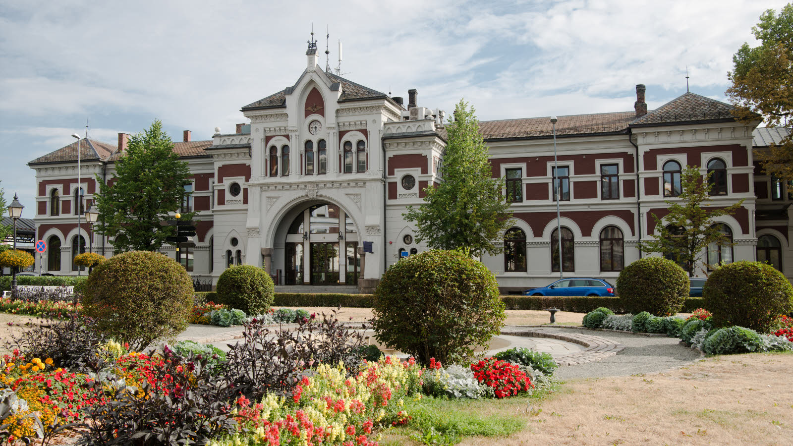 Hamar station with bell tower and greenery.