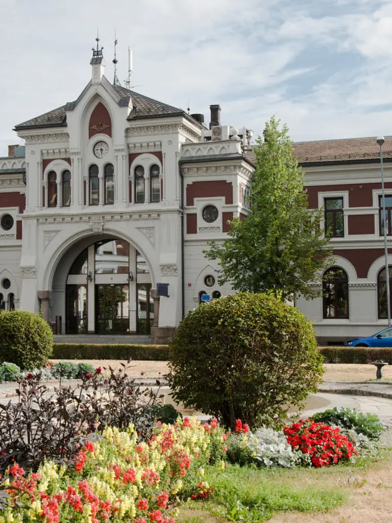 Hamar station with bell tower and greenery.