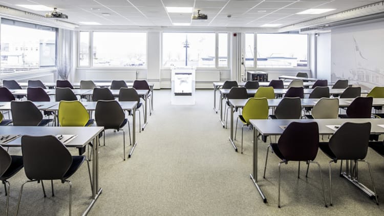 Lyst mødelokale præsenteret med klasseværelse-opsætning