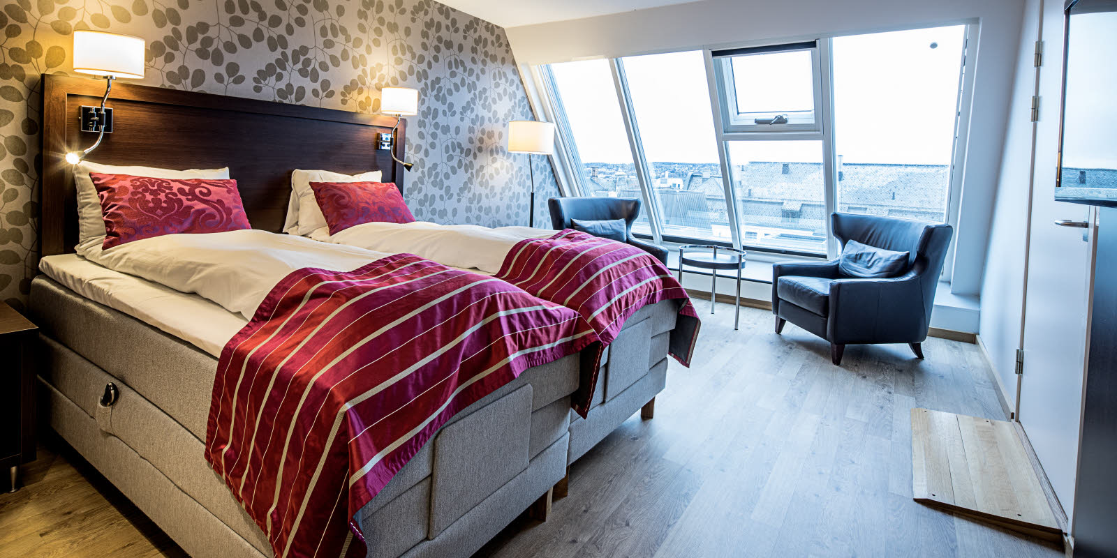 Dobbeltseng og stoler med utsikt mot Mjøsa