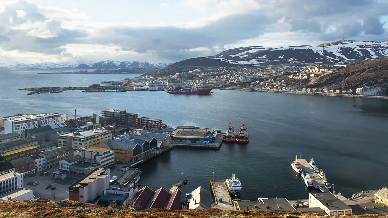 De haven van Hammerfest, met een groot watergebied dat de prachtige hemel en omgeving weerspiegelt.