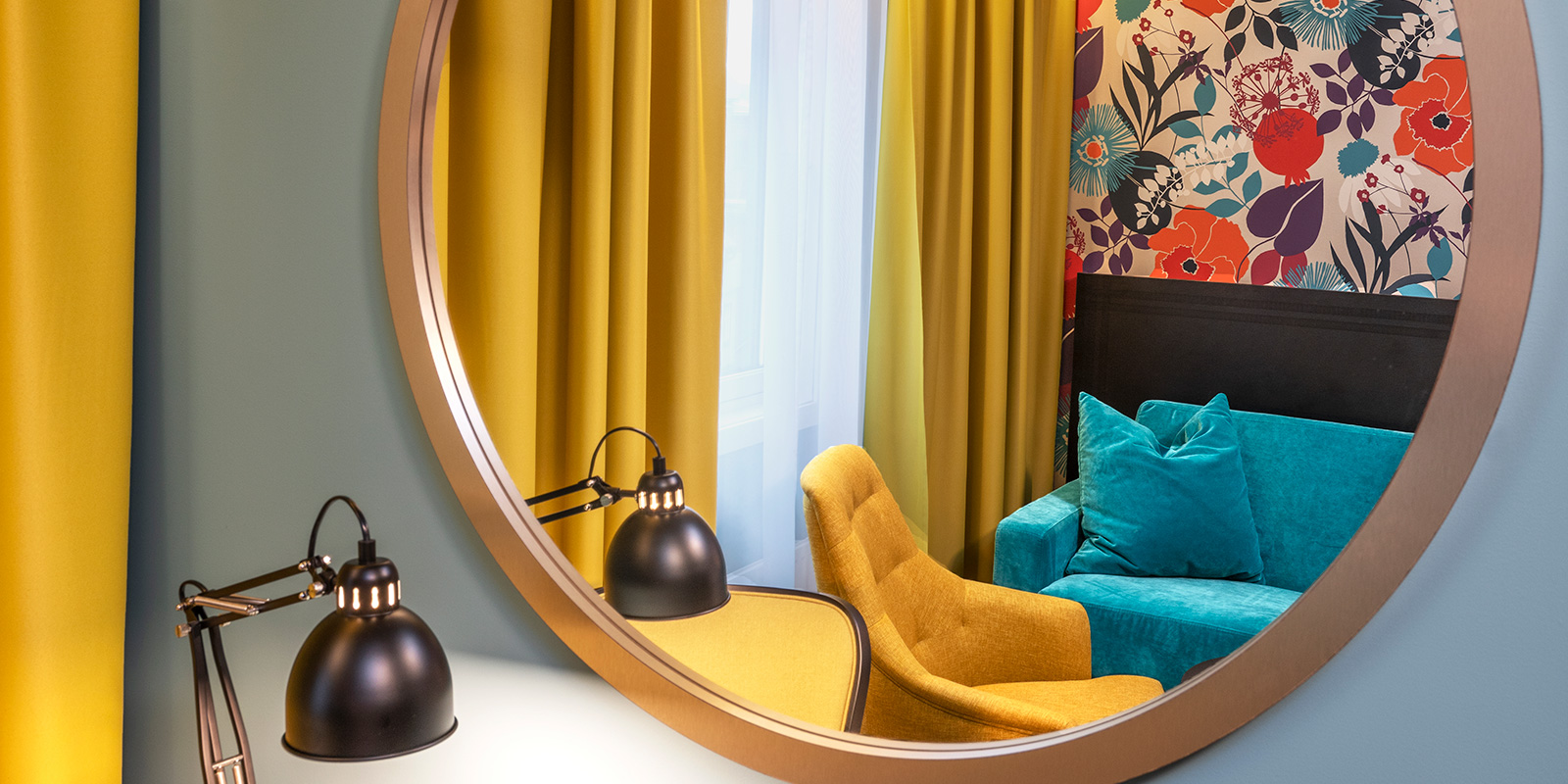 Spejl, siddegruppe og lille bord med lampe