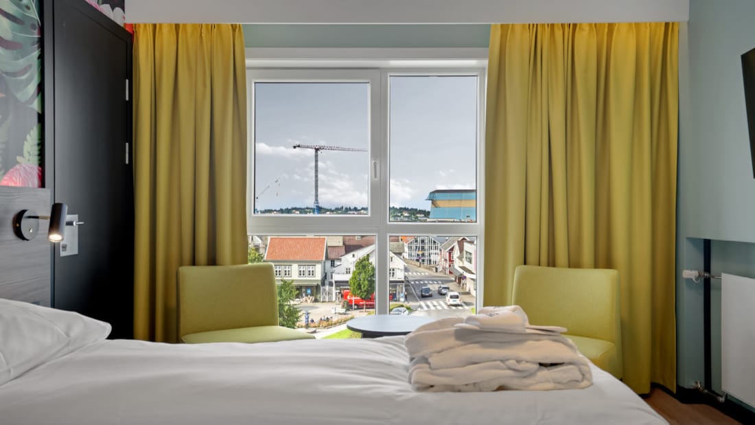 Lyst rom med seng og utsikt til Haugesund by