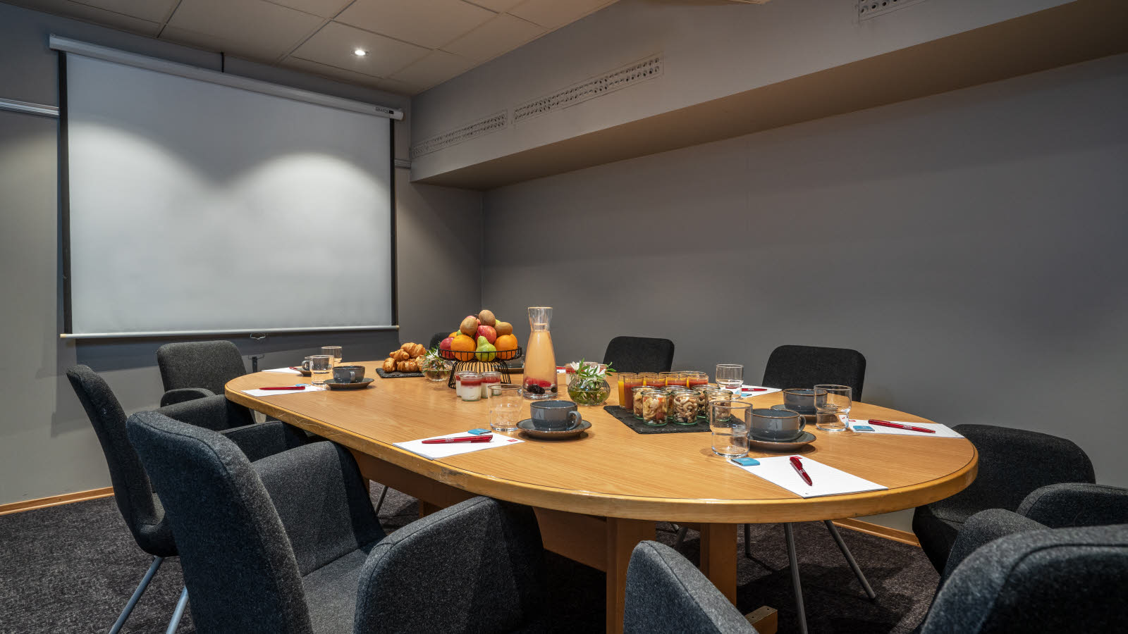 Penna, papper och karameller på skrivbord i möteslokal