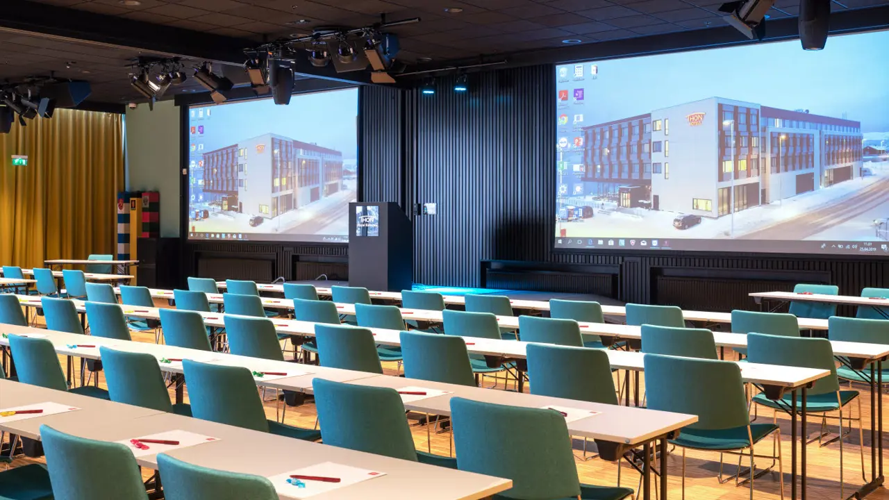Salle de conférence avec disposition en classe, deux écrans et parquet au Thon Hotel Kirkenes.