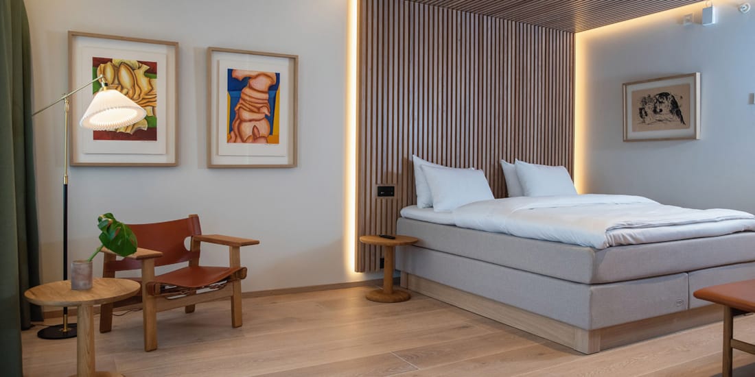 Sitteplass og stor seng i suiten på Hotel Norge