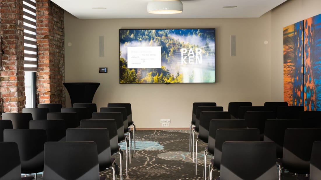 Eik konferencelokale med biografopsætning set mod skærm