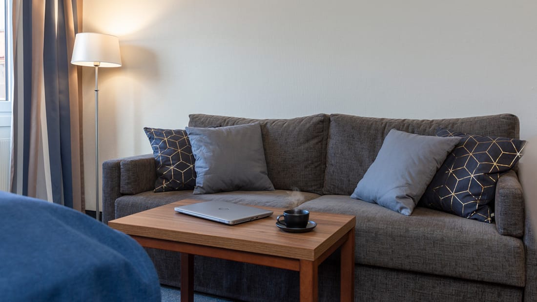 Sofa og bord i rom på Hotel Backlund