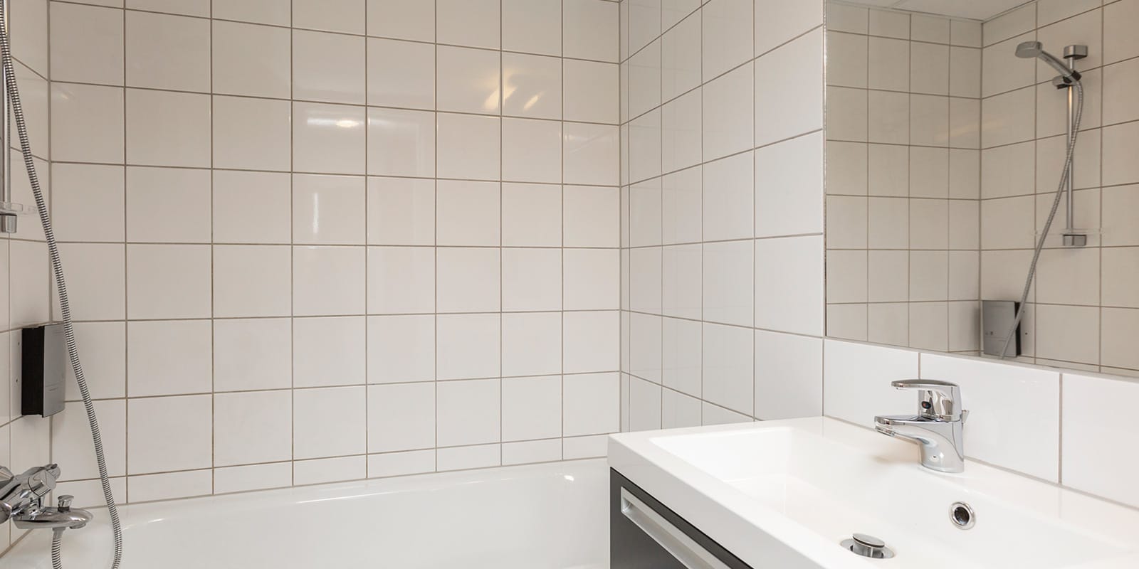 Handfat och dusch med badkar i rum på Hotel Backlund