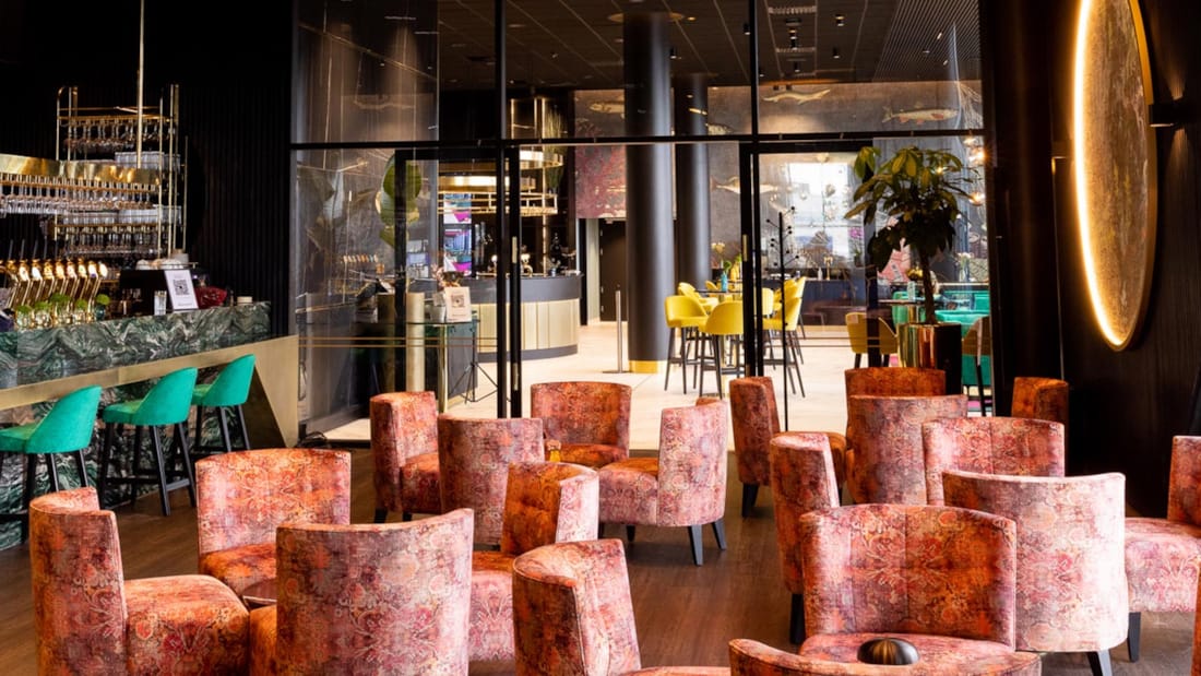Hotellets bar med lyse og fargerike stoler i moderne og stilige lokaler