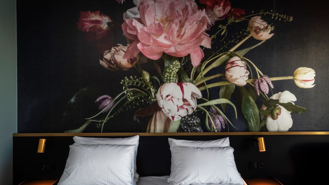 Bilde av kontrastvegg med maleri av blomster ovenfor dobbeltsengen på Standard room dobbel hotellrom på Thon Hotel Svolvær