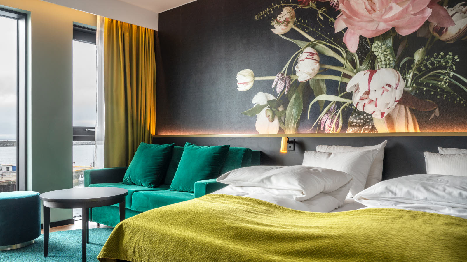 Vierköpfige Familie, die bei einer lächelnden Rezeptionistin in einem Thon Hotel eincheckt