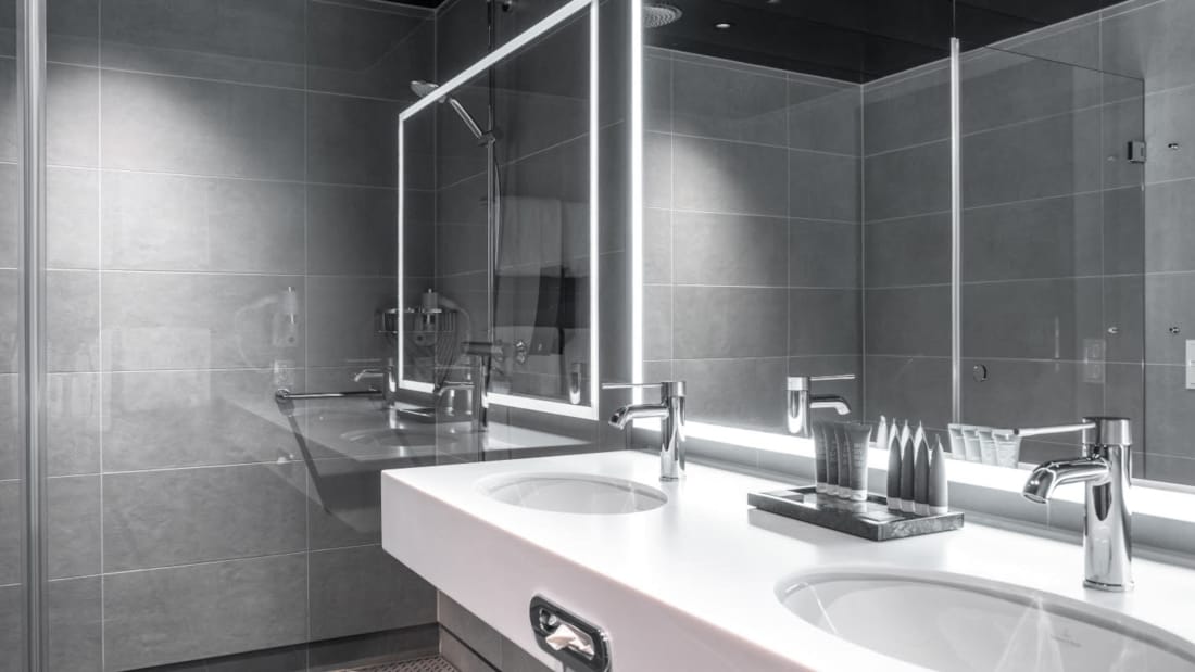 handfat och spegel i badrum i standardrum på Thon Hotel Svolvær