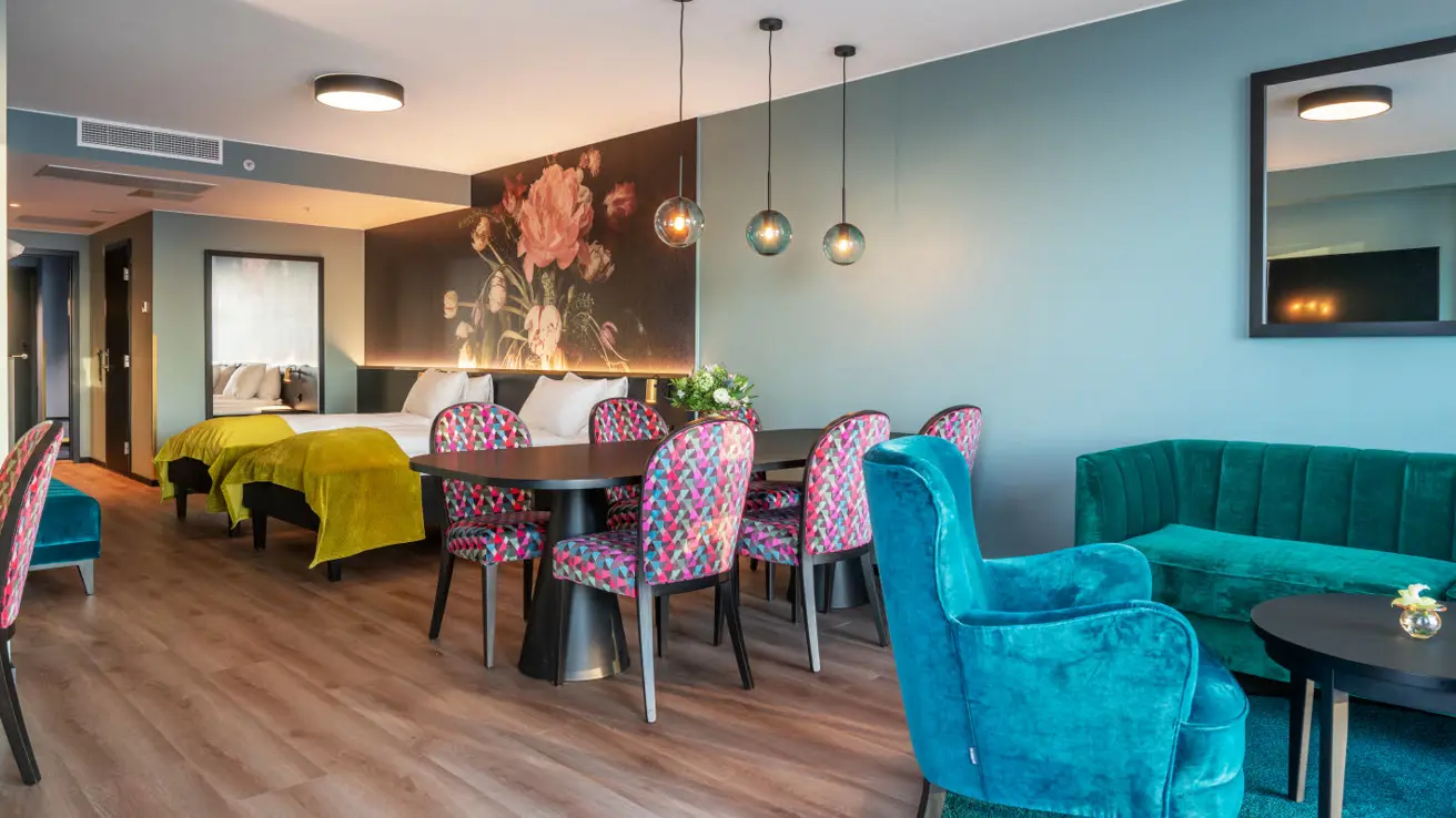bilde av hotellseng, spisebord og sittegruppe på istårnsuite på thon hotel svolvær
