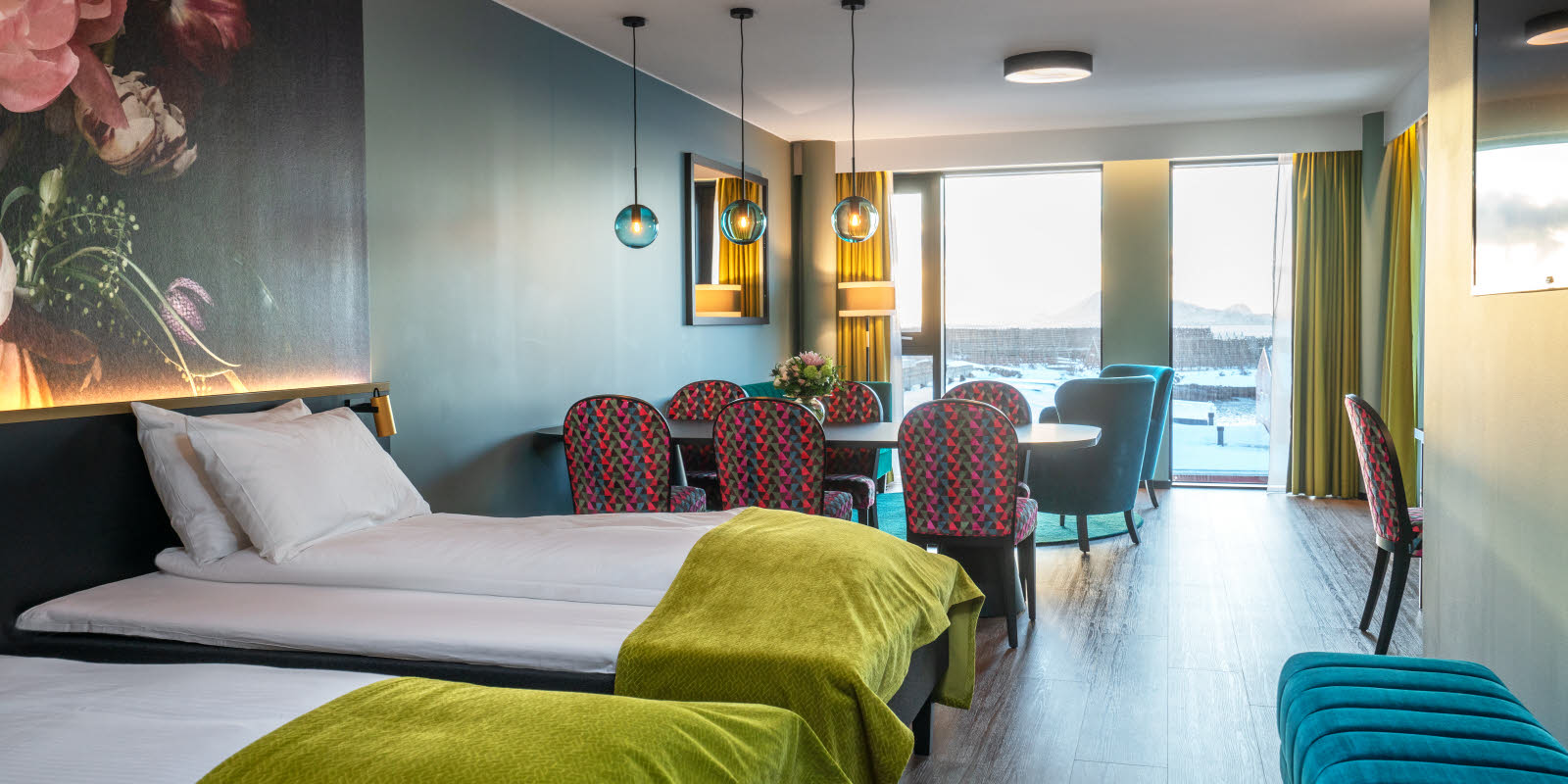 bilde av hotellseng, spisebord og sittegruppe på istårnsuite på thon hotel svolvær
