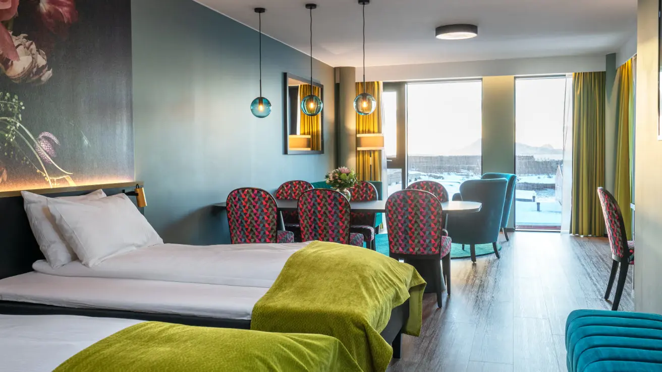 bilde av hotellseng, spisebord og sittegruppe på istårnsuite på thon hotel svolvær