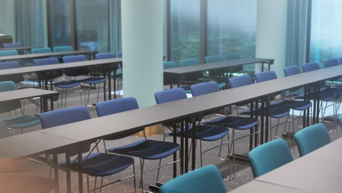 Illustration de la salle de réunion Svartisen avec deux longues tables. Devant, il y a deux grands écrans. Grandes surfaces vitrées sur un long mur.