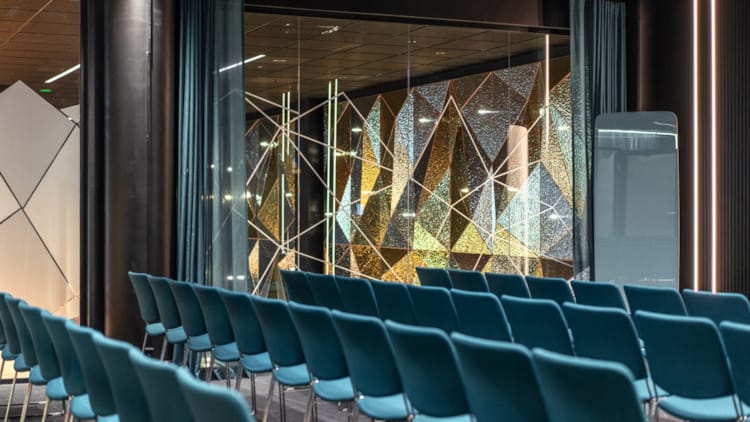 Illustrationsbillede af konferencelokalet Jostedalsbreen med banketopsætning. Mange store vinduesflader, stor skærm på bagvæggen.