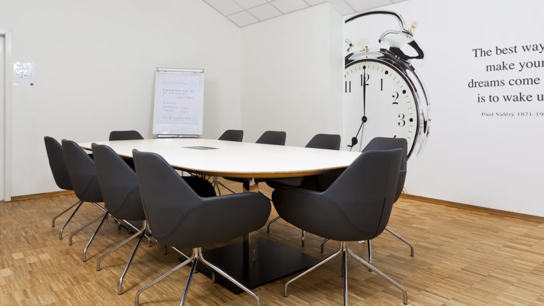 Meeting room with long table and black chairs