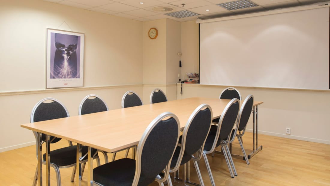 Salle de réunion avec table longue et projecteur